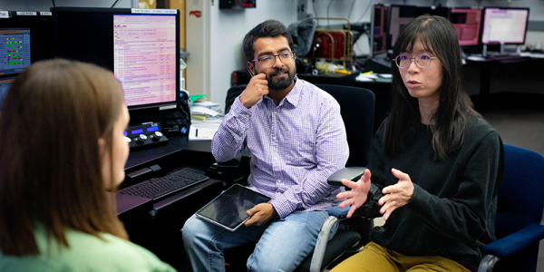researchers in discussion inside SLAC's control room